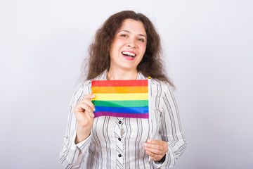 Young lesbian woman holding flags of the LGBT community on a white background