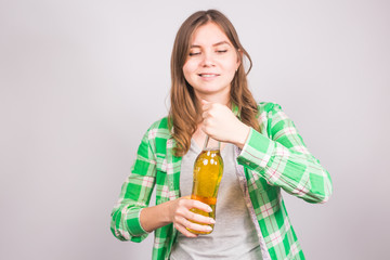 Young woman opens a bottle of beer. Concept of bad habits and alcoholism