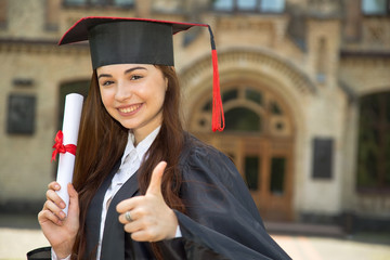 Happy woman portrait on her graduation day University. Education and thumbs up woman.