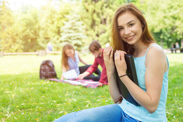 Fototapeta premium Happy student woman. Young female holding a folder with documents to study. Student life everyday.