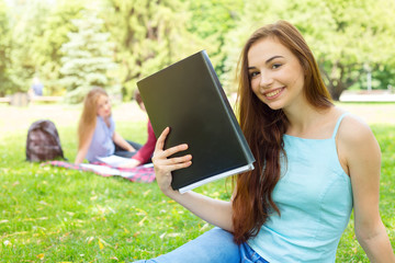 Obraz premium Young female student holding a folder and shows the tasks for training. Student weekdays. Happy woman.