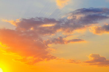 Beautiful sunset yellow and orange sky with clouds and sunshine on a sunny day in summer