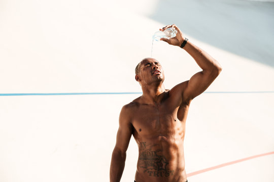 Photo Of Young African Sports Man Pouring Out Water On His Head