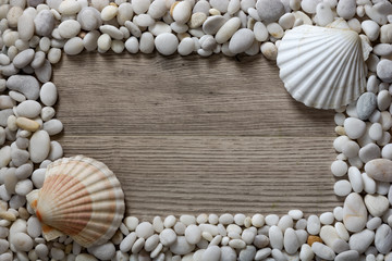 Fototapeta na wymiar Frame of white mramor stones and seashells on wooden background