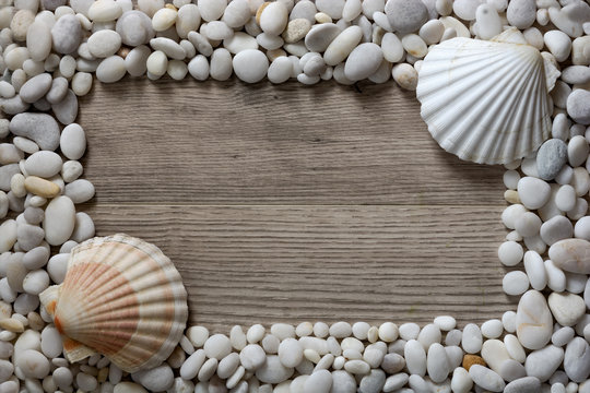 Frame of white mramor stones and seashells on wooden background