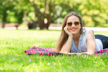 Beautiful girl. Woman looking sideways in a summer green park. Portrait of beautiful smiling young woman.