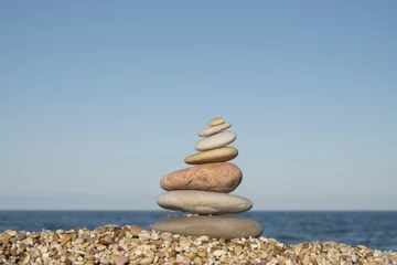 Foto op Plexiglas gestapelde stenen aan de kust © twanwiermans