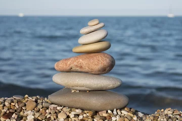Fotobehang gestapelde stenen aan de kust © twanwiermans