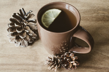 A cup of hot tea with lemon on a rustic table.
