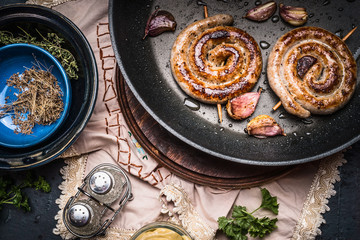 Traditional roasted sausage in frying pan, top view. German food concept