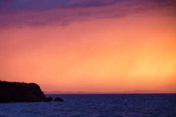 Fototapeta premium Sunset at sea during storm and rain.