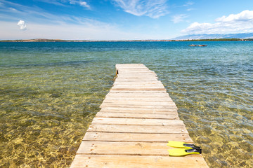 Sea landscape with islands on background, wooden pier with fins, Croatia, Europe.