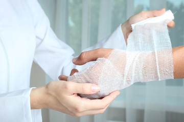 The nurse bandages the patient's hand