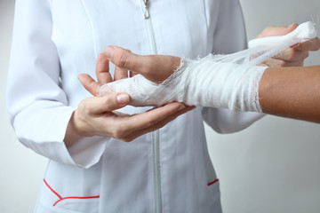 A nurse bandages a patient's hand