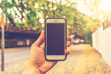 man holding a white smartphone in street