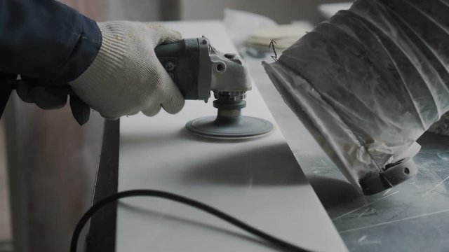 Engineer engraver cleans the surface of the stone slab for further processing, the slab is part of the marble fireplace
