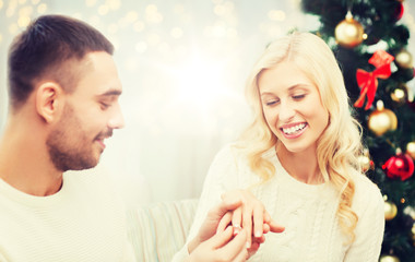Obraz na płótnie Canvas man giving woman engagement ring for christmas