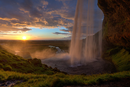 Blick hinter dem Wasserfall zum Sonnenuntergang © Vera