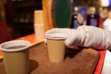 Fototapeta na wymiar hand with cup of mulled wine at christmas market