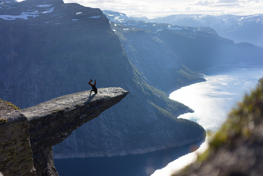 Kopfstand auf einem abstehenden Fels