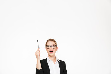 Happy blonde business woman in eyeglasses pointing and looking up