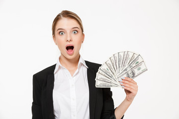 Shocked blonde business woman holding money and looking at camera