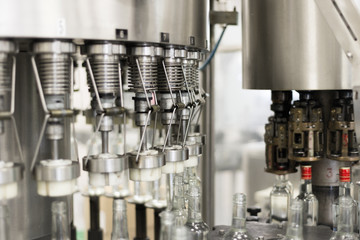 Filling glass bottles with liquid.