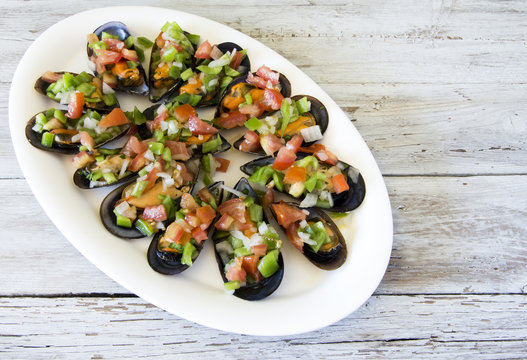 Vinaigrette mussels served on a plate.