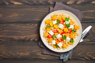 Autumnal salad with chickpea, pumpkin, feta, parsley and chili, top view, copy space.