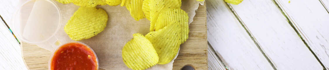 Horizontal bakground of potato chips on a table