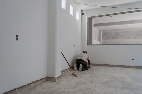 hombre poniendo azulejos en una construcci&oacute;n