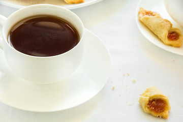 Tea time with Polish cream cheese cookies (Kolacky) with apple jam on white table cloth