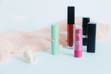 various lipstick bottles with scarf and shell