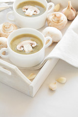 Obraz na płótnie Canvas Two bowl with traditional mushroom soup cream on white table cloth