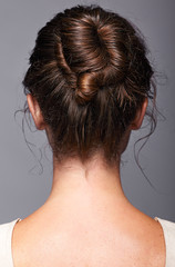 Head and shoulders of a young woman from the back side. Female hair knotted © Serg Zastavkin