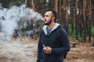 Man with beard smoking electronic sigarette outdoor