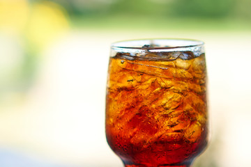 A glass of cola served with ice cubes