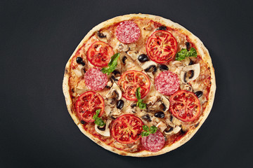 Raw pizza dough with ingredients for cooking vegetarian pizza on the dark stone surface with border