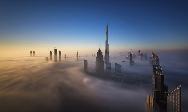 Dubai city view of tall buildings above the mist aerial view