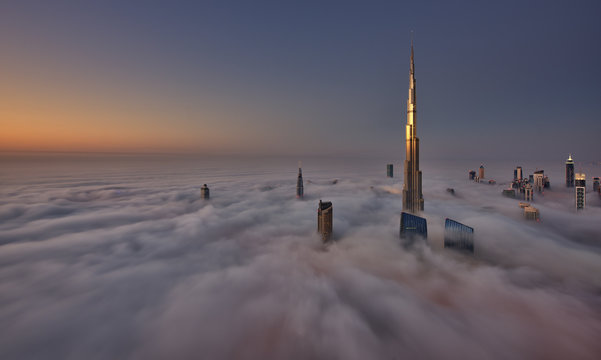 Dubai city view of tall buildings above the mist aerial view