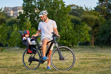 Fototapeta premium Cheerful family biking in park