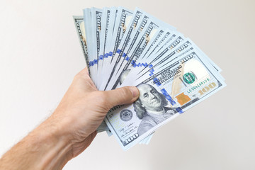 Fan of One Hundred Dollars notes in male hand