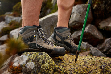 Hiking man with trekking boots on the trail