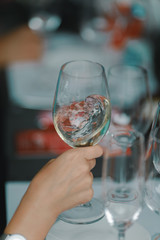 Female hand holding a glass of white wine during wine tasting