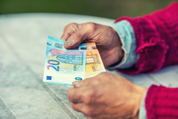 Pensioner man holding in hands euro banknotes