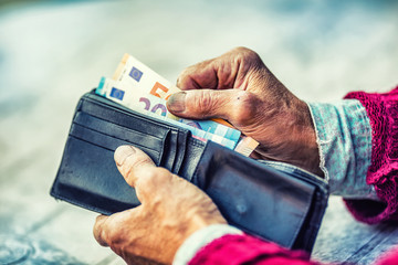Pensioner man holding in hands wallet with money