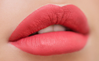 Cosmetics, makeup and trends. Bright lip gloss and lipstick on lips. Close up of beautiful female mouth with red and pink lip makeup. Beautiful part of female face. Perfect clean skin