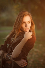 portrait of beautiful young woman posing outdoors looking sideway