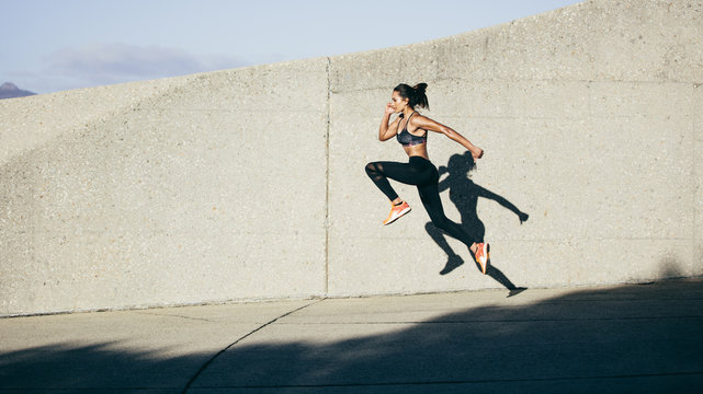 Athletic woman running and jumping outdoors