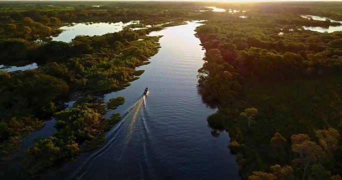 Boat sails in river towards sunset. Mato Grosso do Sul state, Central-Western - Brazil. Vertical panoramic goes up.